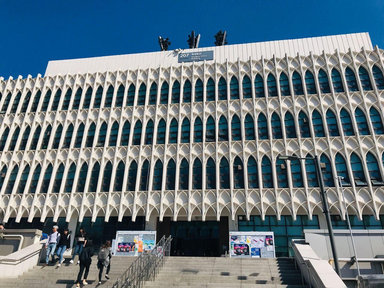 延世大学的商学厅，周围绿树环绕，环境清新。